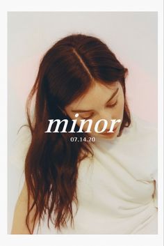 a woman with long brown hair wearing a white shirt and the words minorr on it