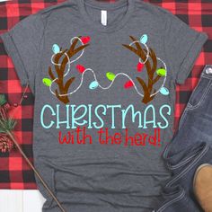 christmas with the herd t - shirt on a plaid table cloth next to a pair of jeans