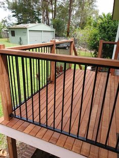 a wooden deck with black iron railings