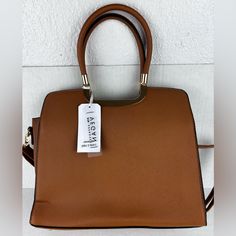 This Park Avenue Collection Purse Is A Versatile Accessory Suitable For Various Occasions. With A Square Shape And A Zip Closure, This Medium-Sized Bag Has A Width Of 12.5 Inches, A Height Of 10 Inches, And A Depth Of 4.5 Inches. The Bag Is Made Of Pvc With A Brown Exterior And Features A Detachable Strap, An Adjustable Strap, And A Crossbody Strap. Trendy Tan Office Bags, Trendy Tan Satchel With Detachable Strap, Tan Satchel Box Bag, Medium Sized Bags, Park Avenue, Square Shape, Crossbody Strap, Brown Gold, Cross Body Handbags