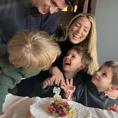 a group of people standing around a cake