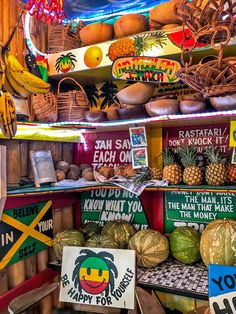 there are many fruits and vegetables on the shelves in this market place, including bananas, pineapples, watermelon, melons