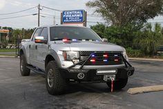 a police truck parked in a parking lot with its lights on and the license plate reading central fires department