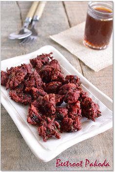 beetroot pekols on a white plate next to a jar of honey