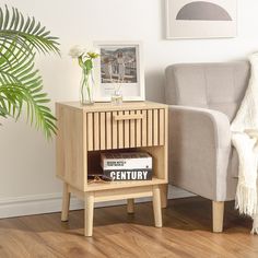 a living room with a couch, chair and side table in the corner that has a magazine on it