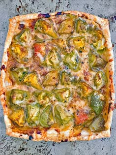 a square pizza sitting on top of a pan covered in cheese and veggies