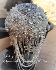 a bridal headpiece with pearls and beads on it's side, sitting on a table