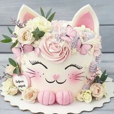 a cake decorated with flowers and a cat's face