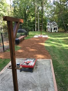 a red bench sitting on top of a cement slab in the middle of a park