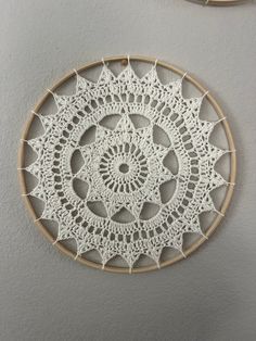 two circular crocheted doily hanging on the wall