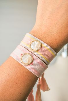 a close up of a person's arm wearing a bracelet with two pearls on it