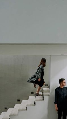 two people are standing on the stairs in an empty room