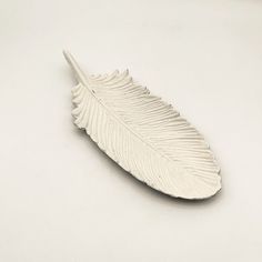 a white feather ornament sitting on top of a table