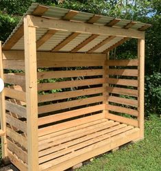 a wooden bench made out of pallets in the grass with a white frisbee