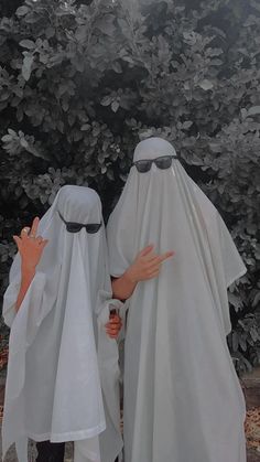 two people dressed in white standing next to each other