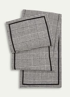 two pieces of black and white checkered fabric on top of each other, one in the