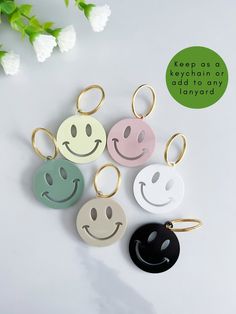 four keychains with smiley faces on them, one is black and the other has white