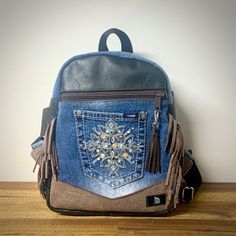 Get noticed with your small backpack with multiple exterior and interior pockets. Size: 11 x 9 x 3 inches. Made of jeans and leather. Unique model, only 1 of each. Have a unique look with your backpack made of upcycled jeans and leather. Lots of pockets inside and outside. size: 11 x 9 x 3 inches. Very unique model only one available. Everyday Denim Backpack, Travel Denim Backpack, Denim Travel Backpack, Denim Standard Backpack With Zipper Closure, Denim Backpack With Zipper Closure, Daily Denim Backpack, Brown Backpack With Cell Phone Pocket, Casual Leather Backpack With Cell Phone Pocket, Upcycled Jeans