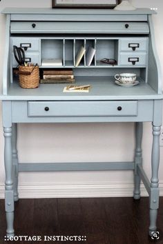 a blue desk with some books on it and a framed photo above the top shelf