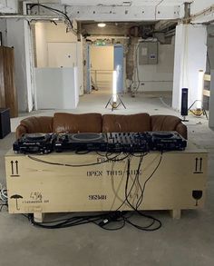 a couch sitting in the middle of a room with dj equipment on top of it