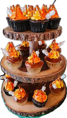 three tiered tray with cupcakes and orange decorations on it's sides