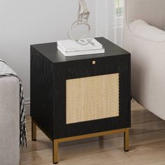 an end table with a basket on top in a living room next to a couch