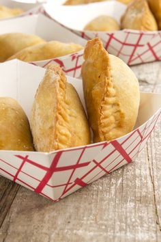 several pastries in red and white boxes on a wooden table