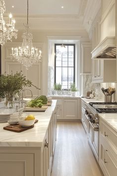 a large kitchen with white cabinets and marble counter tops, along with a chandelier hanging from the ceiling