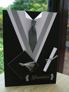 a black card with a tie and white shirt on it is sitting on a table