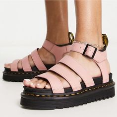 a person wearing pink sandals and black shoes