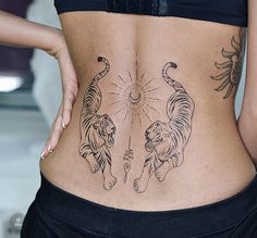 a woman's lower back with tattoos on her body and two tigers in the middle