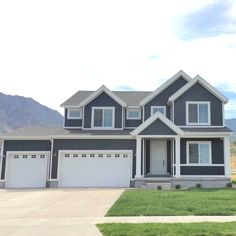 a large gray and white house with two garages