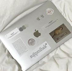 an open laptop computer sitting on top of a white bed covered in sheets and pillows