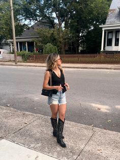 Nashville Outfits With Black Boots, Black Denim Country Outfit, Denim Shorts And Cowboy Boots Outfit, Cowgirl Outfits Shorts, Cowgirl Boots With Shorts, Country Concert Outfit Black Boots, Denim Shorts And Boots Outfit, Outfits With Black Cowgirl Boots, Black Cowgirl Boots Outfit