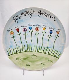 a painted plate with flowers and the words granny's garden on it in black writing