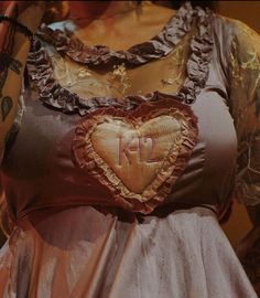 a woman in a dress with a heart shaped decoration on her chest