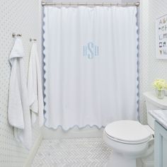 the monogrammed shower curtain in this bathroom is white and blue