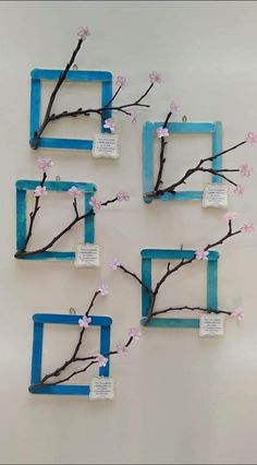 four blue frames with pink flowers on them