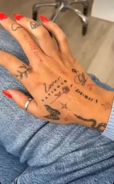 a woman's hand with tattoos on it