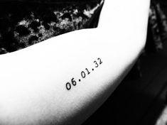 a person with a tattoo on their arm that reads 6 00 12, and has the date