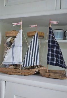 a sailboat in a glass bottle on top of a white shelf next to other items