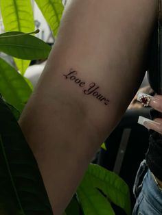 a woman's arm with a tattoo that reads, love you on the side