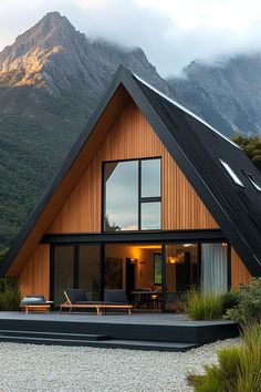 a wooden house with a mountain in the backgrouund and some grass on the ground