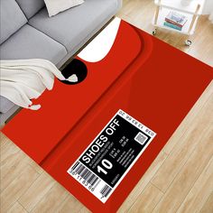 a red carpet with a black and white price label on it in front of a gray couch