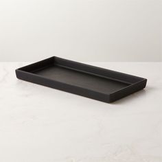 an empty black tray on a white table