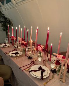 a long table is set with candles, plates and napkins for an elegant dinner