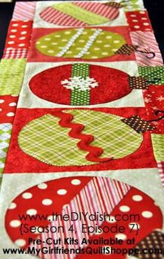 a quilted table runner with christmas ornaments on it