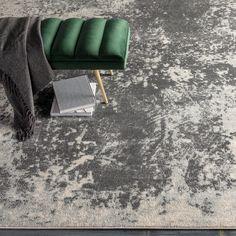 a green bench sitting on top of a rug next to a gray and white carpet