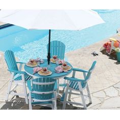 a table with chairs and an umbrella next to a pool