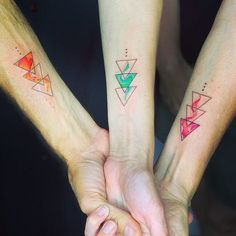 three people holding hands with matching tattoos on their arms and one has a triangle tattoo on the wrist